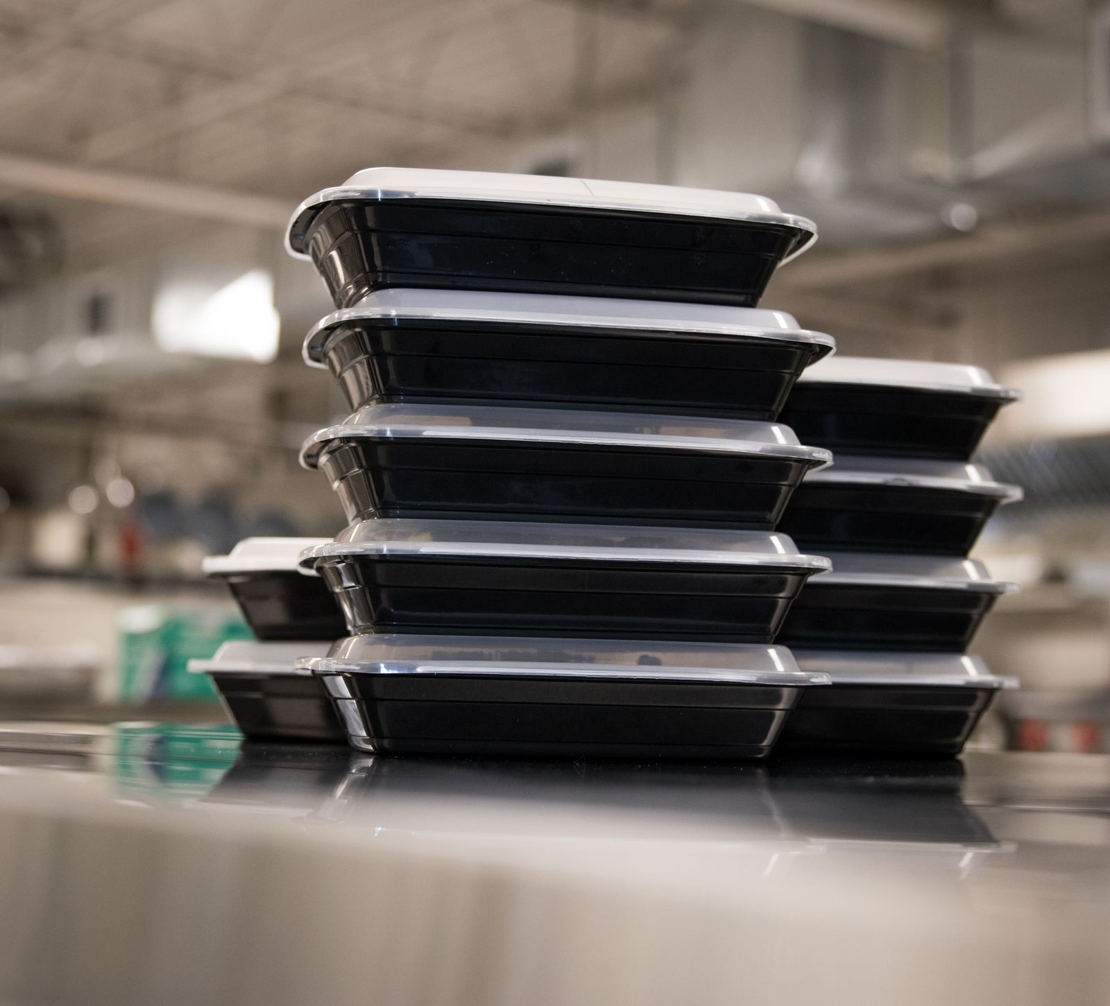 A stack of packed Nutrics meal containers from a partner kitchen's production run